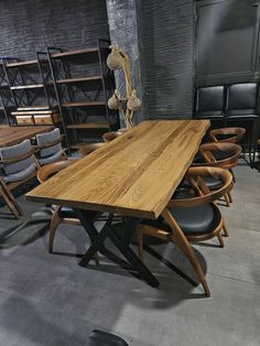 a wooden table surrounded by chairs in a room