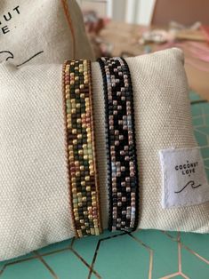 three bracelets sitting on top of a pillow