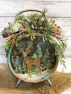 an old fashioned christmas decoration with deer and pine trees