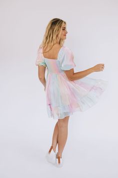 For the days you need more color, we've got you covered. Introducing the Head In The Clouds Dress to our Exclusive collection! A one-of-a-kind dress that is as fun, shimmery, + vibrant as you! Details Iridescent pastels Shimmery look Rainbow colored Lined Short puff sleeves Square neckline Elastic along shoulders Smocked back Tier hem Soft! Mini-length dress Sizing *Measurements are taken with item hanging and fabric unstretched.* Measurements for this style may seem small due to the elastic smo