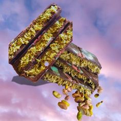 a piece of food flying through the air with nuts coming out of it and on top of it