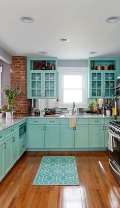 a kitchen with teal cabinets and wood floors is pictured in this image from the front view