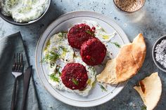 three beet patties on a plate with sour cream and dill