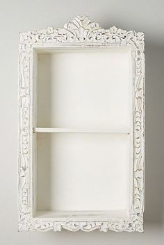 an ornate white shelf with two shelves on each side