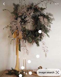 a christmas wreath on a table next to candles and other holiday decorations with the words image search below it