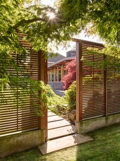 an open wooden gate in the middle of a yard