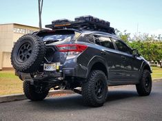 the rear end of a black suv with four wheels on it's flatbed