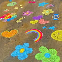 colorful chalk drawings on the ground with flowers, hearts, and other things drawn by children