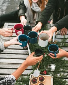 a group of people sitting around each other holding cups