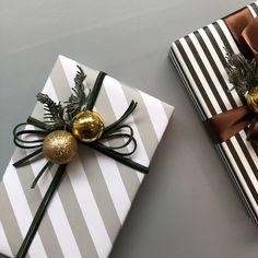 two presents wrapped in wrapping paper with gold ornaments on them