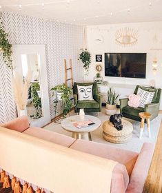 a living room with couches, chairs and a flat screen tv on the wall