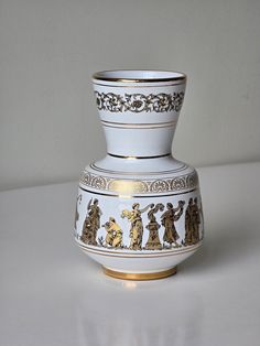 a white and gold vase sitting on top of a table