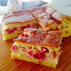 four pieces of cake sitting on top of a wooden cutting board