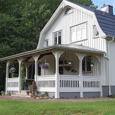 a large white house sitting on top of a lush green field