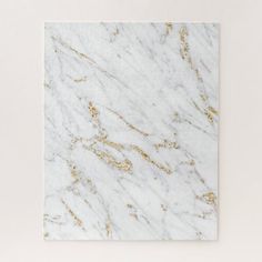 a white marble tile with gold speckles on the edges and bottom, against a white background