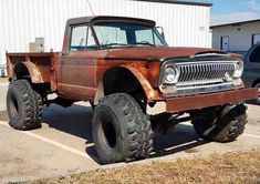 an old rusted truck parked in a parking lot