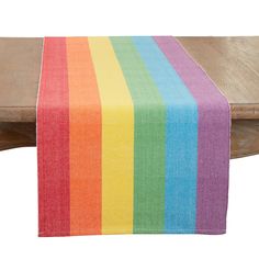 a multicolored table runner sitting on top of a wooden bench