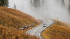 a truck driving down the road on a foggy day