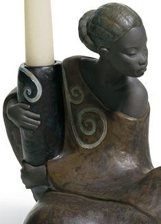 a statue with a candle in it's hand