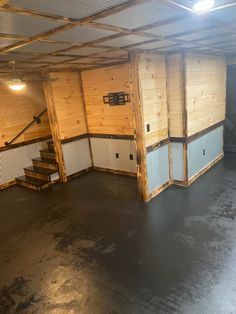 an empty garage with wooden walls and stairs