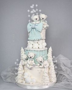 a three tiered cake with teddy bears on top and snowflakes around it