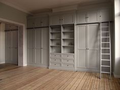 an empty room with wooden floors and built in cabinets on either side of the wall