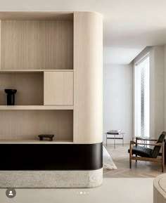 a living room filled with furniture next to a wall mounted shelf on top of a wooden floor