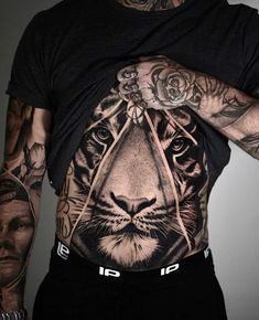 a man with tattoos on his stomach and chest has a tiger tattoo on it's back