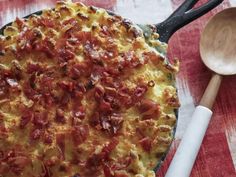 a pizza sitting on top of a pan next to a wooden spoon