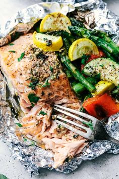 salmon, asparagus, and potatoes on tin foil with a fork in it