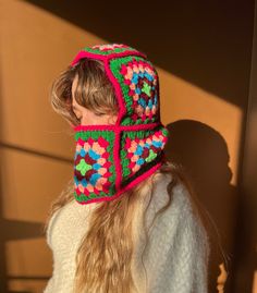 a woman with long hair wearing a colorful knitted beanie hat on her head