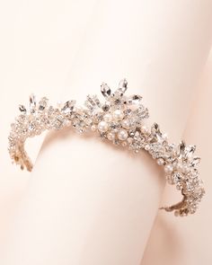 Feel like a princess on your wedding day with our Ophelia Pearl Crown. Made with jeweled scrolls & flowers made of pearls & crystals in perfect peaks, this intricate design will have all eyes on you. Off white pearls, crystals, jeweled scrolls Center peak measures 2" Pin loops are located at each end Style #3436 Crystal Wedding Tiaras