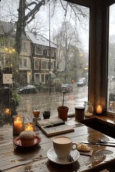 a cup of coffee sitting on top of a wooden table next to a large window