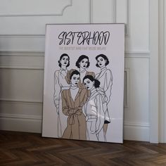 a poster on the floor in front of a white wall with an image of women