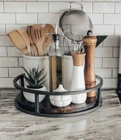 kitchen utensils and wooden spoons are arranged in a holder on the counter