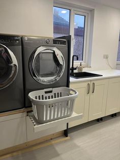 a washer and dryer sitting on top of each other in a kitchen next to a window