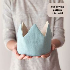 a person holding a blue crown in their hands with a speech bubble above it that says pdd sewing pattern + tutorial