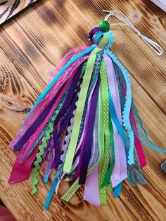 a bunch of ribbons that are on top of a wooden table with a cell phone