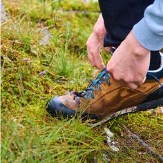 a man tying his shoes in the grass