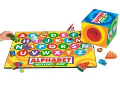 the alphabet and numbers board game is being played by a child with his hands on it