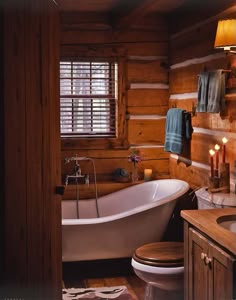 a bathroom with a tub, toilet and sink inside of it next to a window