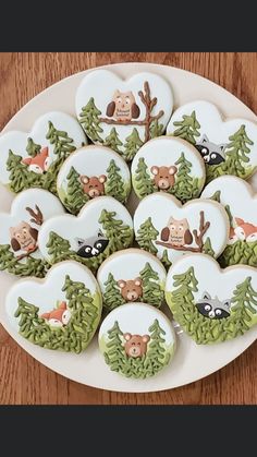 decorated cookies on a plate with forest animals and trees in the shape of heart shapes