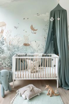 a baby's room with a canopy bed and wall mural