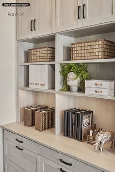 a shelf with books and other items on it in a room that has white cabinets