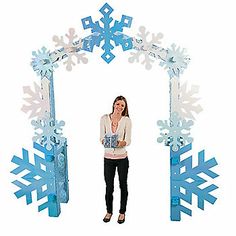 a woman standing in front of an archway made out of snowflakes