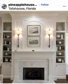 a white fireplace with built - in shelving above it and pictures on the wall