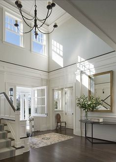 an elegant entryway with stairs and windows