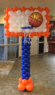 an inflatable basketball hoop with orange and blue balloons