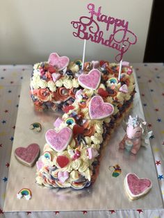 a birthday cake that is shaped like the number one with hearts and marshmallows