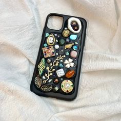 an iphone case with many different items on it sitting on a white sheet covered surface